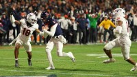 Virginia Cavaliers quarterback Chandler Morris (4) scores a touchdown as Virginia Tech Hokies safety Isaiah Cash (18) and Hokies linebacker Noah Chambers (16) chase in the third quarter at Scott Stadium.