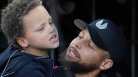 Golden State Warriors guard Stephen Curry (right) holds his son Canon (left) in the San Francisco Giants dugout before the game against the New York Yankees at Oracle Park.
