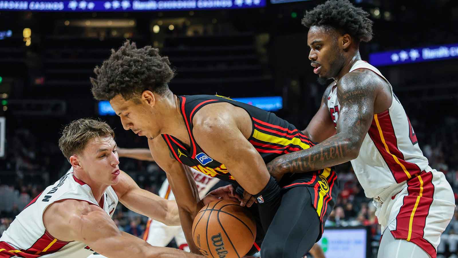 Atlanta Hawks forward Jalen Johnson (1) fights for the ball against Miami Heat guard Pelle Larsson (9) and Miami Heat guard Davion Mitchell (45) during the fourth quarter at State Farm Arena.