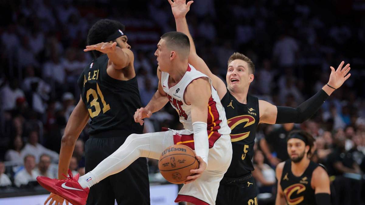 Miami Heat guard Tyler Herro (14) passes the basketball as Cleveland Cavaliers center Jarrett Allen (31) and guard Sam Merrill (5) defend in the first quarter during game four for the first round of the 2025 NBA Playoffs at Kaseya Center.