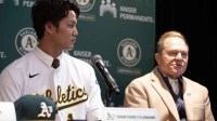 Newly signed pitcher Shintaro Fujinami is introduced by the Oakland Athletics at a press conference. His agent, Scott Boras, sits with him.