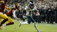 Philadelphia Eagles wide receiver A.J. Brown (11) carries the ball as Washington Commanders cornerback Jonathan Jones (31) and Washington Commanders linebacker Frankie Luvu (4) defend during the first half at Northwest Stadium.