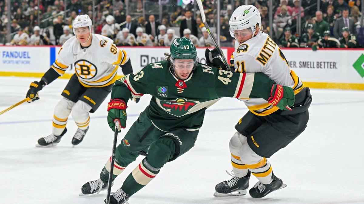 Minnesota Wild defensemen Quinn Hughes (43) protects the puck from Boston Bruins forward Casey Mittelstadt (11) during the second period at Grand Casino Arena.