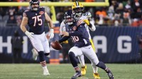 Chicago Bears quarterback Caleb Williams (18) runs with the ball and offensive tackle Ozzy Trapilo (75) watches the play against Green Bay Packers defensive end Brenton Cox Jr. (57) during overtime at Soldier Field.