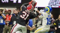 Atlanta Falcons safety Xavier Watts (31) intercepts a pass over Los Angeles Rams wide receiver Xavier Smith (19) during the first half at Mercedes-Benz Stadium