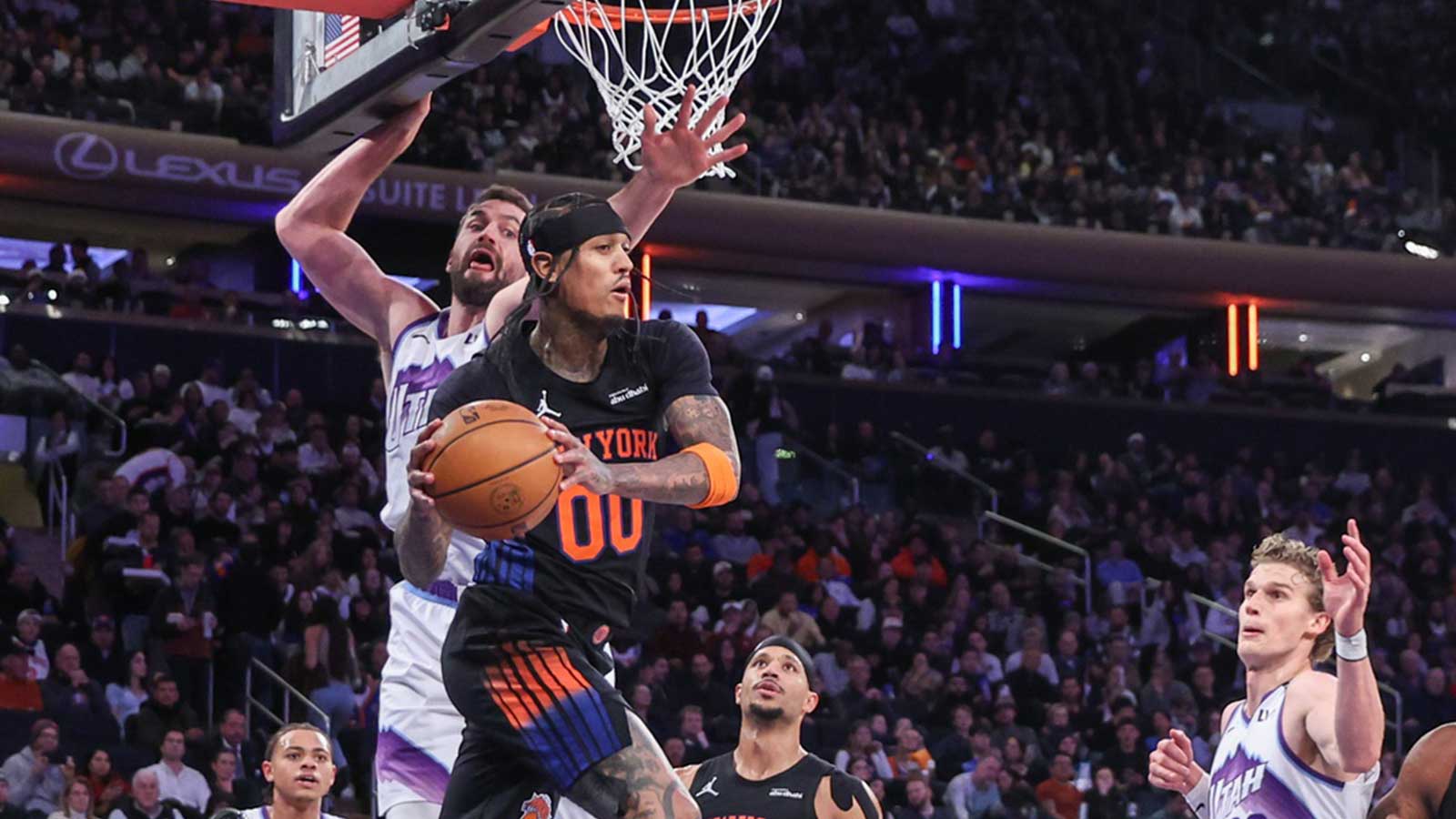 Dec 5, 2025; New York, New York, USA; New York Knicks guard Jordan Clarkson (00) looks to make a pass after driving past Utah Jazz forward Kevin Love (42) in the third quarter at Madison Square Garden. Mandatory Credit: Wendell Cruz-Imagn Images