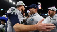 Seattle Seahawks head coach Mike MacDonald embraces quarterback Sam Darnold (14) after defeating the Los Angeles Rams in overtime at Lumen Field.