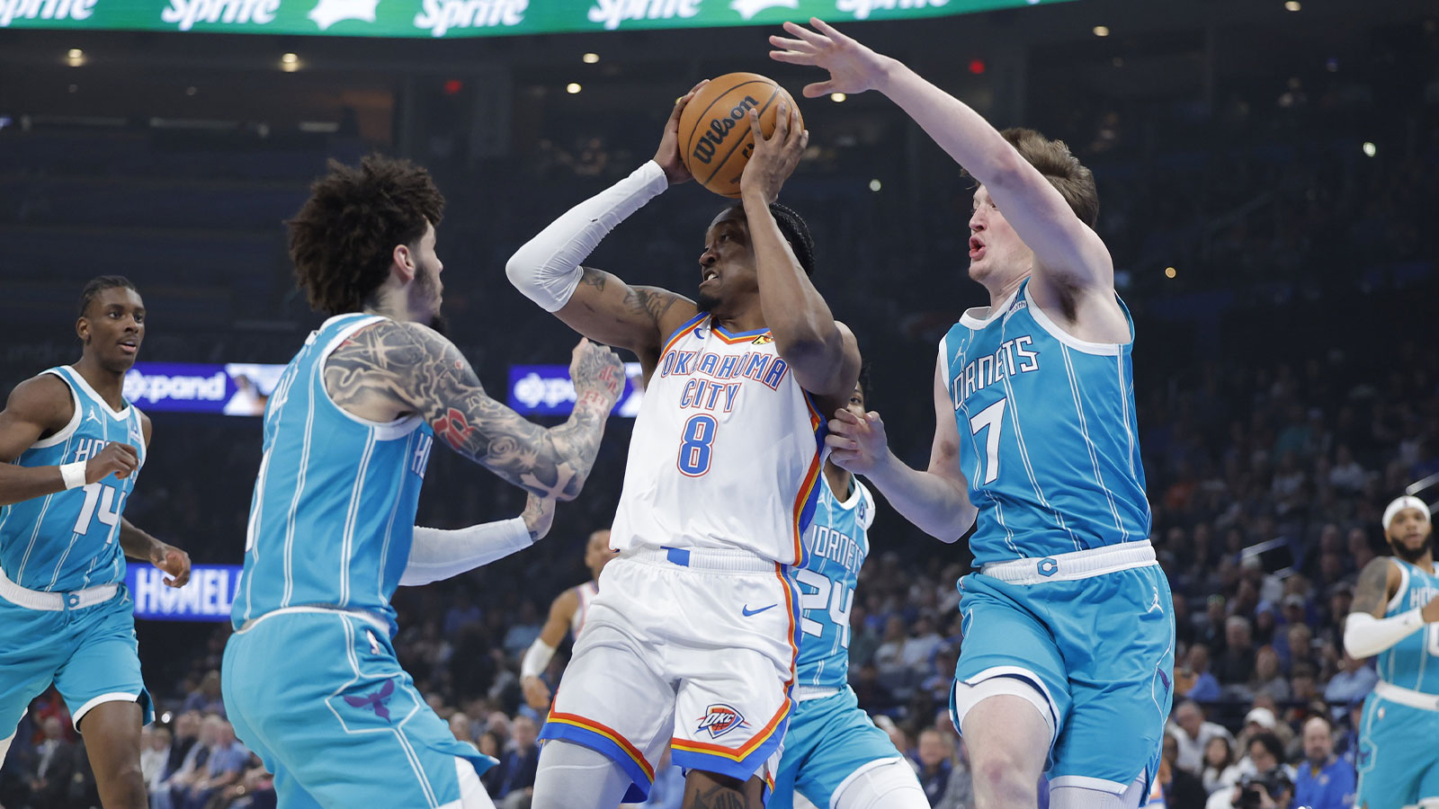 Oklahoma City Thunder guard Jalen Williams (8) passes between Charlotte Hornets guard Lamelo Ball (1) and guard Kon Knueppel (7) during the first quarter at Paycom Center.
