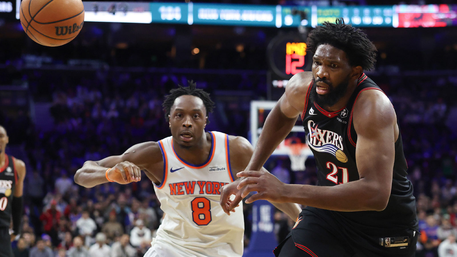 Philadelphia 76ers center Joel Embiid (21) chases a loose bal in front of New York Knicks forward Og Anunoby (8) during the fourth quarter at Xfinity Mobile Arena.