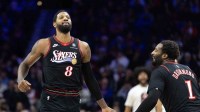 Philadelphia 76ers forward Paul George (8) reacts with center Andre Drummond (1) after dunking the ball against the Brooklyn Nets during the second quarter at Xfinity Mobile Arena.