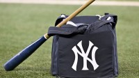 A view of a baseball bat and a New York Yankees bag and logo before the game between the Texas Rangers and the Yankees at Globe Life Field.