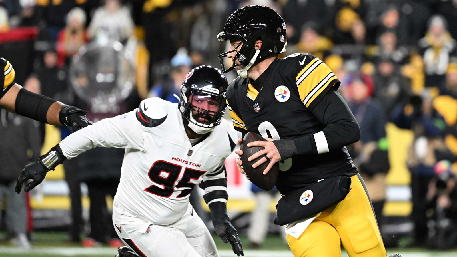 Pittsburgh Steelers quarterback Aaron Rodgers (8) scrambles from Houston Texans defensive end Derek Barnett (95) during the first half of an AFC Wild Card Round game at Acrisure Stadium.