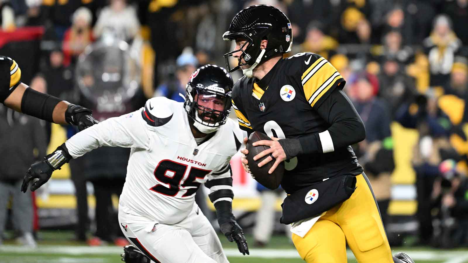 Pittsburgh Steelers quarterback Aaron Rodgers (8) scrambles from Houston Texans defensive end Derek Barnett (95) during the first half of an AFC Wild Card Round game at Acrisure Stadium.