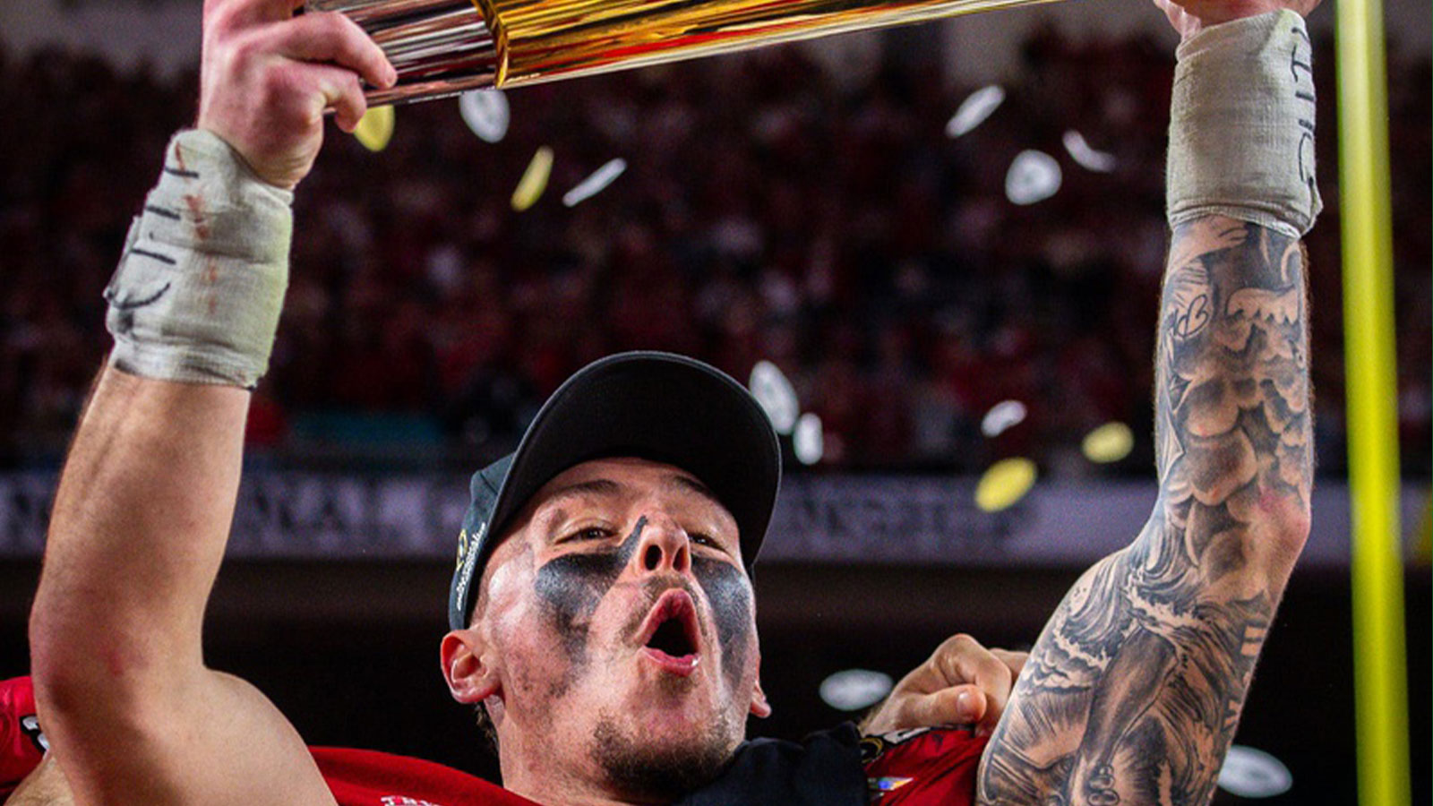 Indiana's Aiden Fisher (4) hoists the trophy after the College Football Playoff National Championship college football game at Hard Rock Stadium in Miami Gardens on Monday, Jan. 19, 2026.