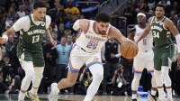Oklahoma City Thunder guard Ajay Mitchell (25) strips the ball away from Milwaukee Bucks guard Ryan Rollins (13) in the first half at Fiserv Forum.