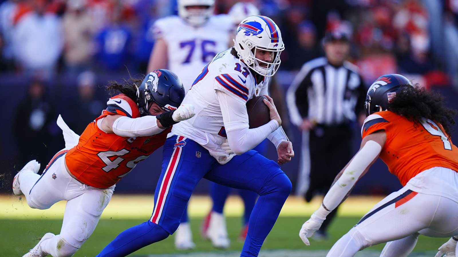 Buffalo Bills quarterback Josh Allen (17) runs against Denver Broncos linebacker Alex Singleton (49) and safety Talanoa Hufanga (9) during the second quarter of an AFC Divisional Round playoff game at Empower Field at Mile High.