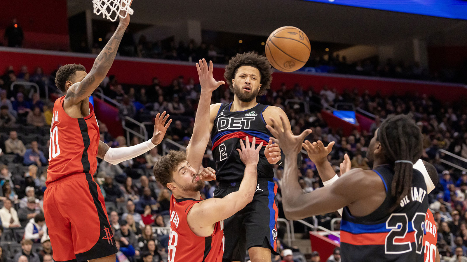 Houston Rockets center Alperen Sengun (28) defends as Detroit Pistons guard Cade Cunningham (2) passes the ball to forward Isaiah Stewart (28) during the second half at Little Caesars Arena.