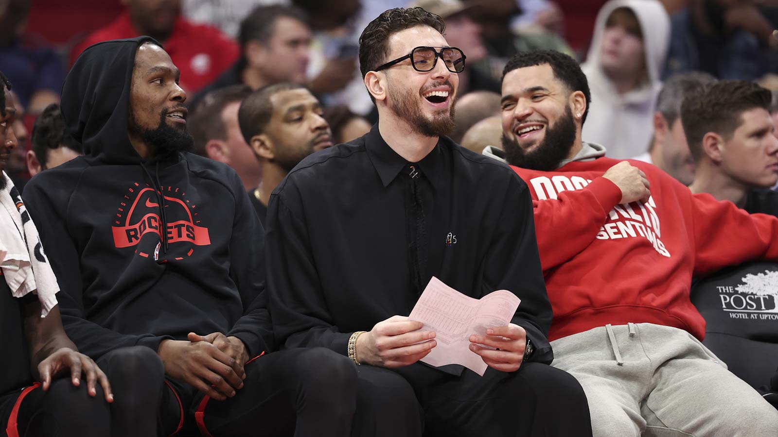 Houston Rockets center Alperen Sengun (middle) laughs on the bench with forward Kevin Durant (left) and guard Fred Vanvleet (right) during the second half against the Cleveland Cavaliers at Toyota Center.
