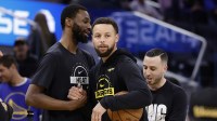 Miami Heat forward Andrew Wiggins (22) and Golden State Warriors guard Stephen Curry (30) greet each other before the game at Chase Center.