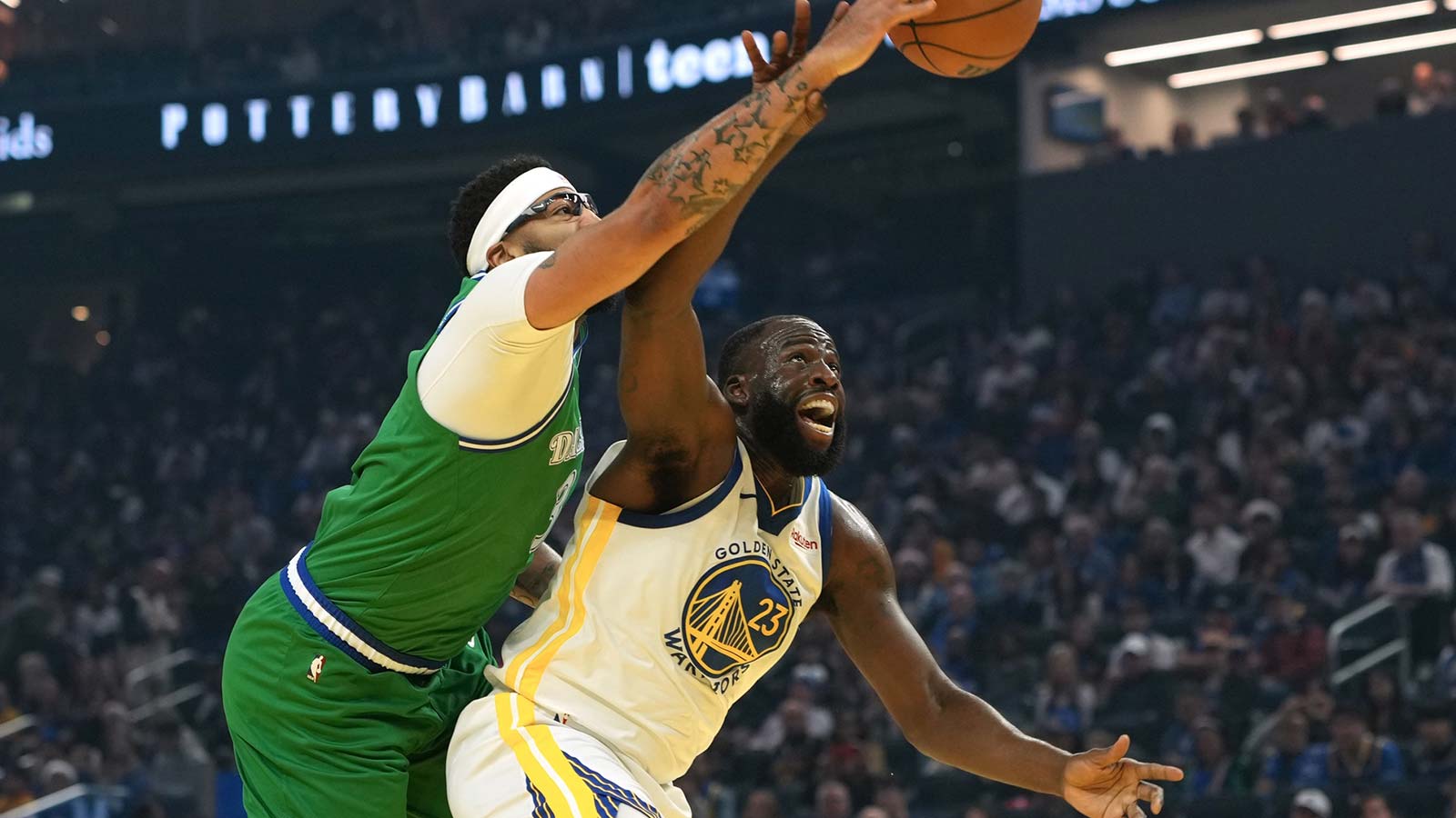 Golden State Warriors forward Draymond Green (23) rebounds against Dallas Mavericks forward Anthony Davis (center left) during the first quarter at Chase Center. 