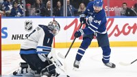 Winnipeg Jets goalie Eric Comrie (1) makes a save on a shot from Toronto Maple Leafs forward Auston Matthews (34) in the third period at Scotiabank Arena.