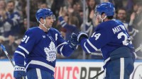 Toronto Maple Leafs forward Auston Matthews (34) congratulates forward John Tavares (91) for scoring an empty net goal against the Ottawa Senators during the third period at Scotiabank Arena.