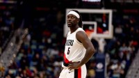 Trail Blazers guard Jrue Holiday (5) slaps hands with Portland forward Toumani Camara (33) after a play against the New Orleans Pelicans during the second half at Smoothie King Center with the Rockets logo in the background