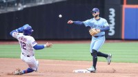 Toronto Blue Jays shortstop Bo Bichette (11) throws past New York Mets shortstop Francisco Lindor (12) to complete a double play in the first inning at Citi Field.