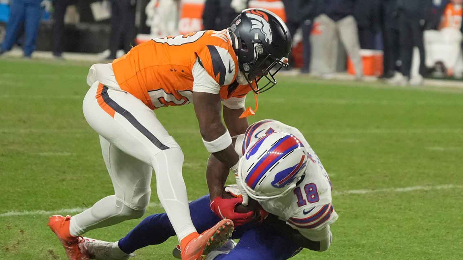 Denver Broncos cornerback Ja'quan McMillian reaches in on Buffalo Bills wide receiver Brandin Cooks who has the ball and whose knee is on the ground during overtime at Empower FIeld at Mile High in Denver, Colorado on Jan. 17, 2026.
