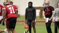San Francisco 49ers wide receiver Brandon Aiyuk (in black hoodie) watches his teammates work out during the second day of training camp.