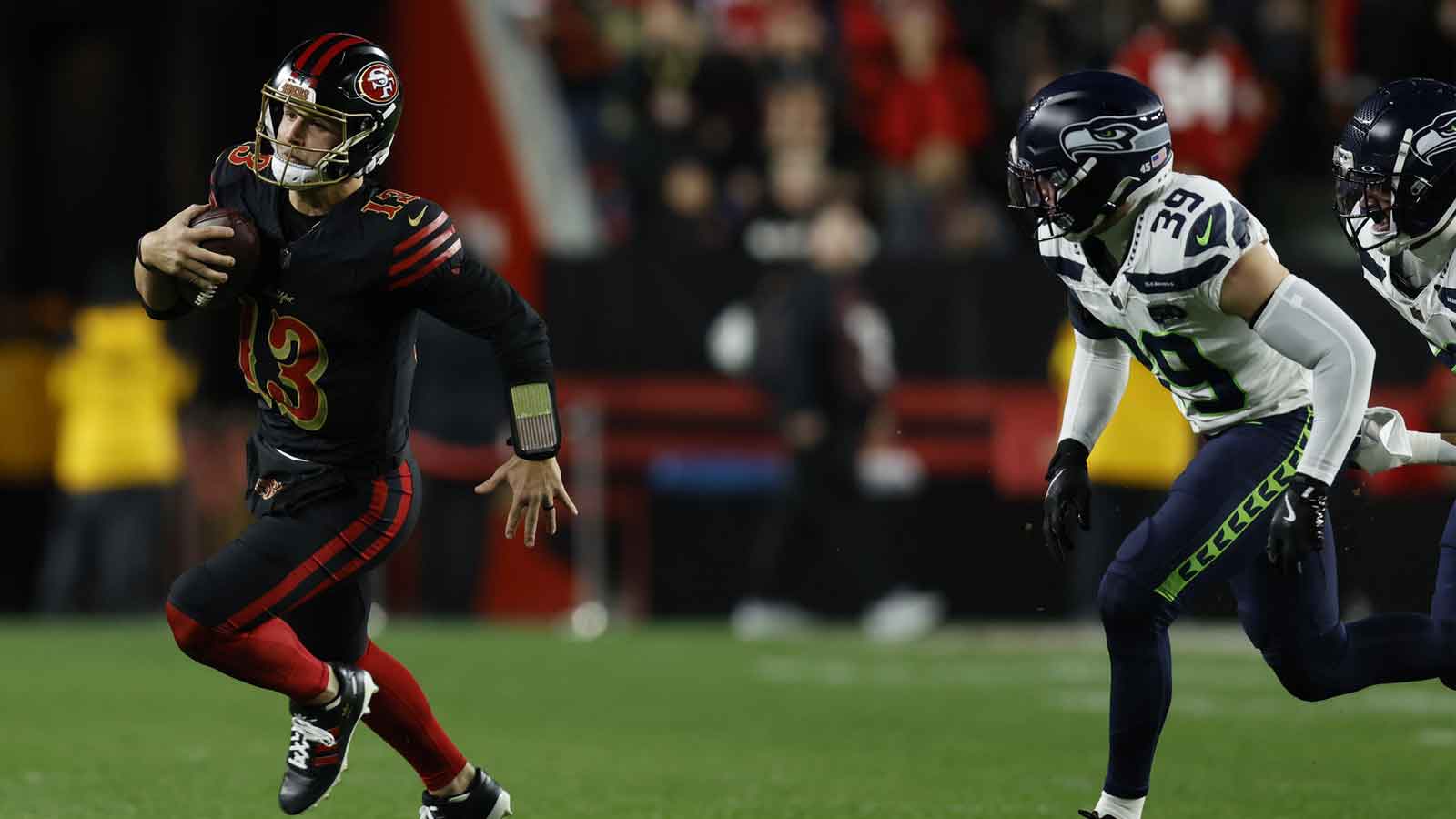 San Francisco 49ers quarterback Brock Purdy (13) rushes the ball past Seattle Seahawks safety Ty Okada (39) during the first half at Levi's Stadium.