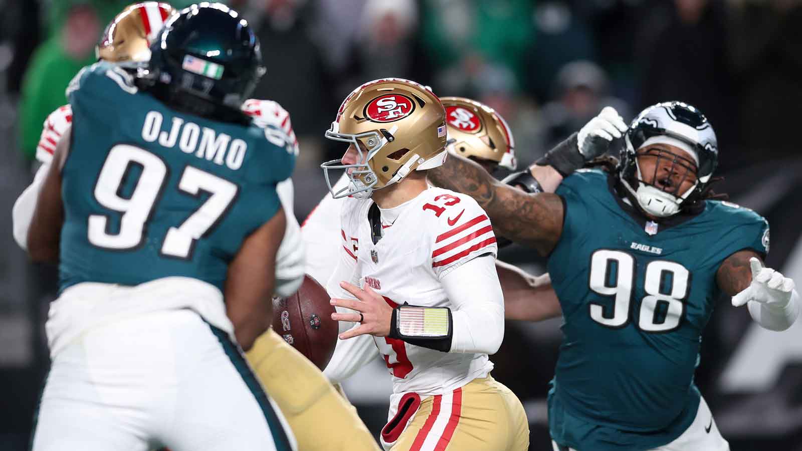 San Francisco 49ers quarterback Brock Purdy (13) looks to pass the ball under pressure from Philadelphia Eagles defensive tackle Moro Ojomo (97) and defensive tackle Jalen Carter (98) during the third quarter in an NFC Wild Card Round game at Lincoln Financial Field.