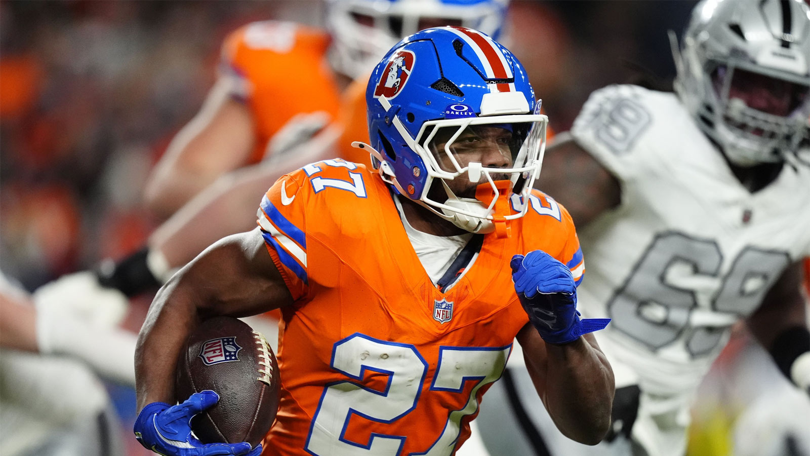 Denver Broncos running back J.K. Dobbins (27) rushes the ball against the Las Vegas Raiders during the first half at Empower Field at Mile High
