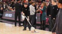 A United Center employee mops the court. The game between the Chicago Bulls and the Miami Heat is delayed because of condensation on the floor due to rain and humidity at United Center.