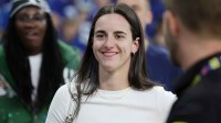 Caitlin Clark looks on from the sideline during warmups before the game between the Las Vegas Raiders and the Indianapolis Colts at Lucas Oil Stadium.