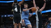 Memphis Grizzlies guard Cam Spencer (24) drives to the basket as San Antonio Spurs guard De'Aaron Fox (4) and center Luke Kornet (7) defend during the third quarter at FedExForum.