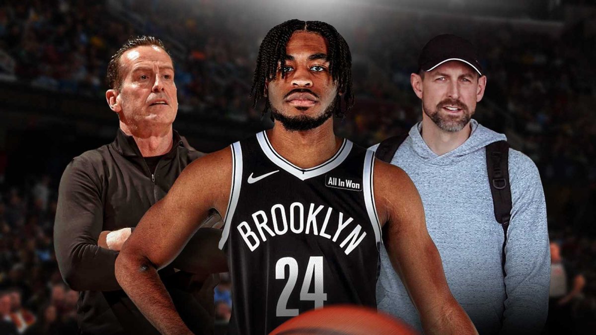 Cam Thomas in the middle, Coach Kenny Atkinson and GM Mike Gansey around him, Cleveland Cavaliers wallpaper in the background