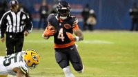 Chicago Bears running back D'Andre Swift (4) runs runs after the catch as Chicago Bears defensive end Kingsley Enagbare (55) defends during the second half of an NFC Wild Card Round game at Soldier Field.