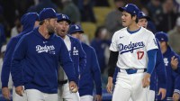 Los Angeles Dodgers catcher Austin Barnes (15), pitcher Clayton Kershaw (22) and designated hitter Shohei Ohtani (17) walk to the field after the final out of the ninth against the San Francisco Giants at Dodger Stadium.