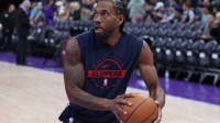 Clippers forward Kawhi Leonard (2) warms up before the game against the Utah Jazz at Delta Center with the Nuggets logo in the background