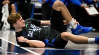 Dallas Mavericks forward Cooper Flagg (32) grabs his ankle as he falls to the floor during the second quarter against the Denver Nuggets at the American Airlines Center.