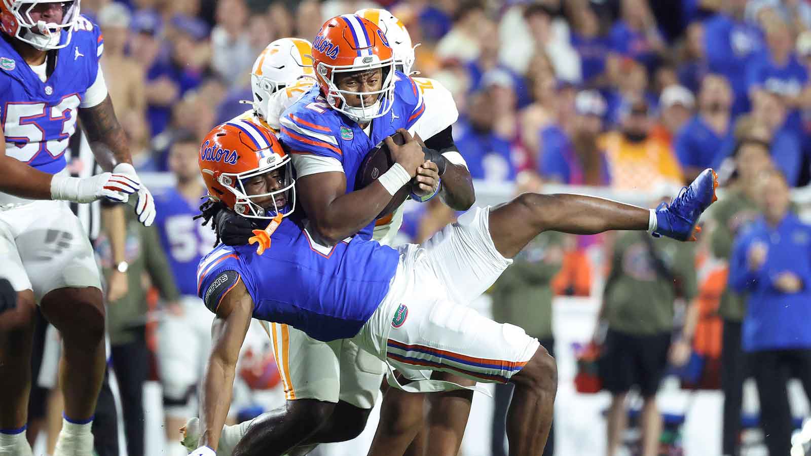 Florida Gators quarterback DJ Lagway (2) runs into Florida Gators wide receiver TJ Abrams (4) as he runs with the ball and Tennessee Volunteers defensive lineman Tyre West (42) defends during the second half at Ben Hill Griffin Stadium.