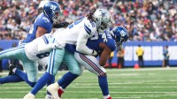 Dallas Cowboys defensive end Jadeveon Clowney (42) and Dallas Cowboys safety Donovan Wilson (6) tackle New York Giants running back Devin Singletary (26) during the second quarter at MetLife Stadium.