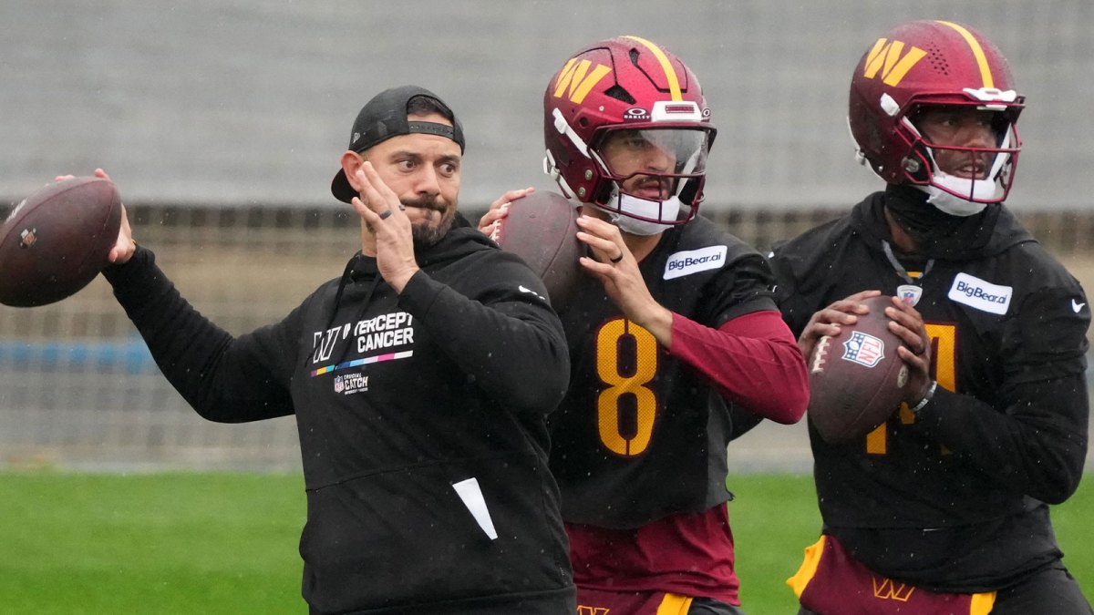 Washington Commanders assistant quarterbacks coach David Blough (left) and quarterbacks Marcus Mariota (8) and Josh Johnson (14) throw the ball during practice at Ciudad Deportiva del Real Madrid.