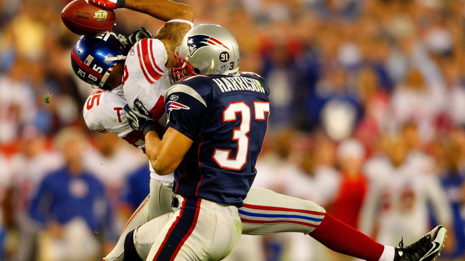 Giants receiver David Tyree catches a pass while in the clutches of Patriots safety Rodney Harrison en route to New York's 17-14 victory over New England in Super Bowl XLII.