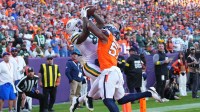 Green Bay Packers running back Josh Jacobs (8) catches a touchdown pass under pressure from Denver Broncos linebacker Dre Greenlaw (57) during the second quarter at Empower Field at Mile High.