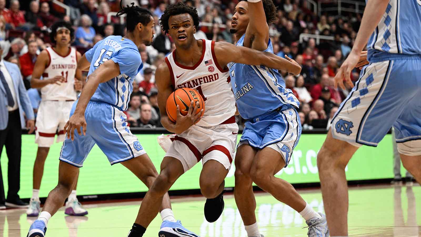 Stanford Cardinal guard Ebuka Okorie (1) drives to the basket against North Carolina Tar Heels guard Seth Trimble (7) and forward Jarin Stevenson (15) in the first half at Maples Pavilion.