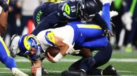 Los Angeles Rams quarterback Matthew Stafford (9) dives for a first down against Seattle Seahawks linebacker Ernest Jones IV (13) during the second half in the 2026 NFC Championship Game at Lumen Field.