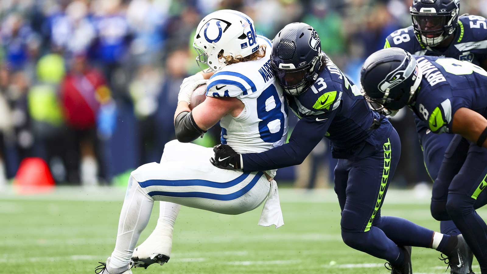 Seattle Seahawks linebacker Ernest Jones IV (13) tackles Indianapolis Colts tight end Tyler Warren (84) following a reception by Warren during the second quarter at Lumen Field.
