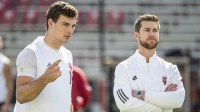 Indiana Hoosiers quarterback Fernando Mendoza (15) speaks with quarterbacks/co-offensive coordinator Chandler Whitmer on the field before the game against the Maryland Terrapins at SECU Stadium.